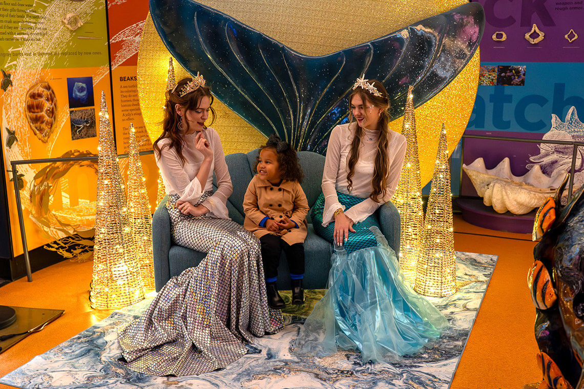 Little girl visits mermaids at the Greensboro Science Center