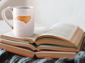 Open books and a mug with the state of North Carolina on it