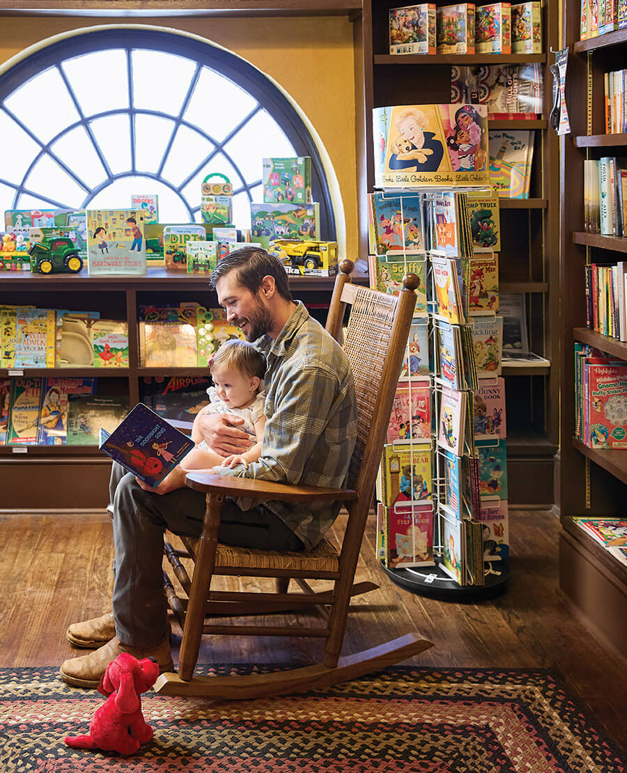 Father and child read in Town Hardware's Book Nook