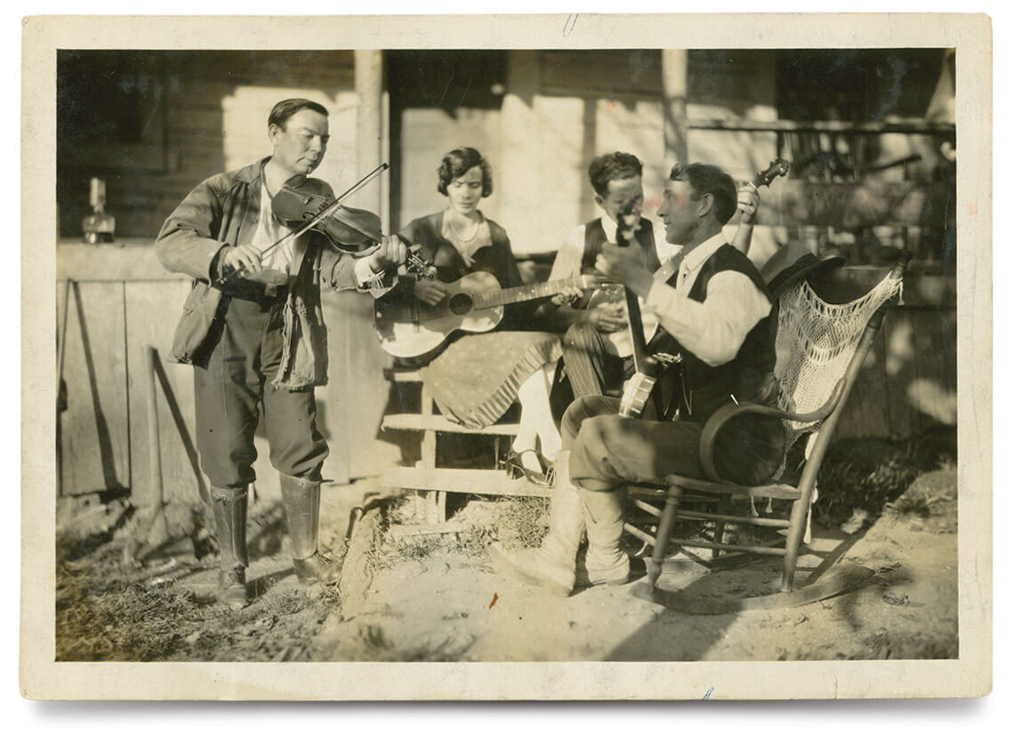 Black and white photo of Bascom Lamar Lunsford playing the fiddle with country musicians