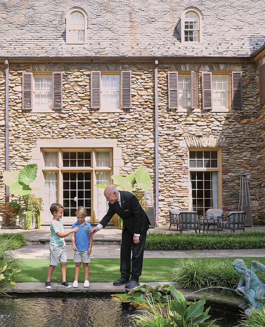 Butler at Graylyn Estate shows children the koi pond