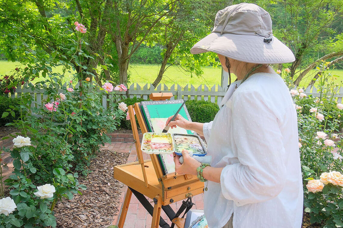 Artist painting in a garden