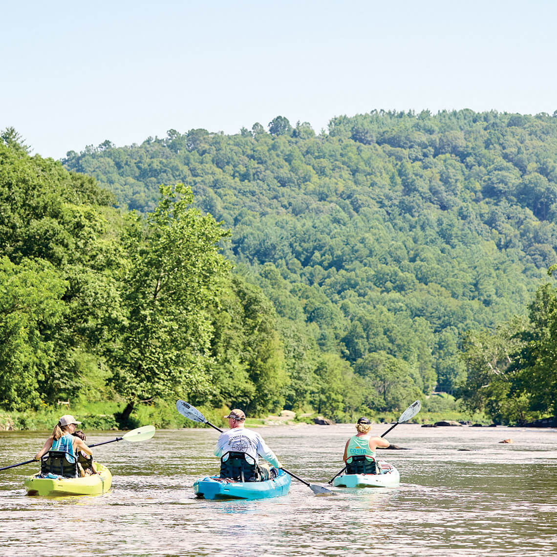 Three people kayak the New River