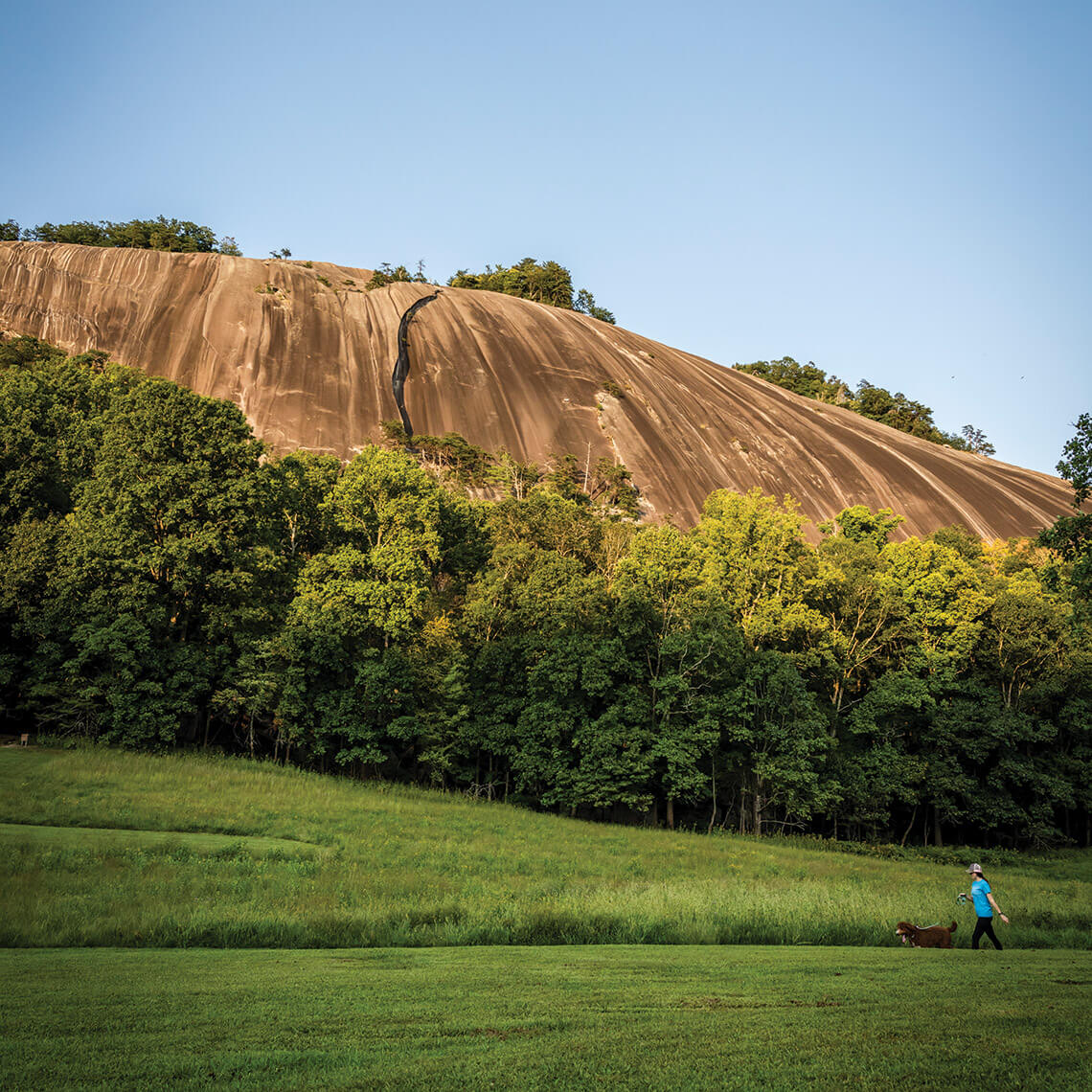 Woman walks dog at Stone Mountain State Park