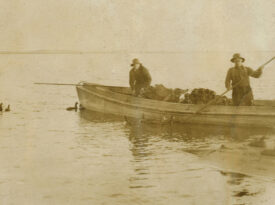 Black and white photo of hunters setting out duck decoys