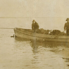 Black and white photo of hunters setting out duck decoys