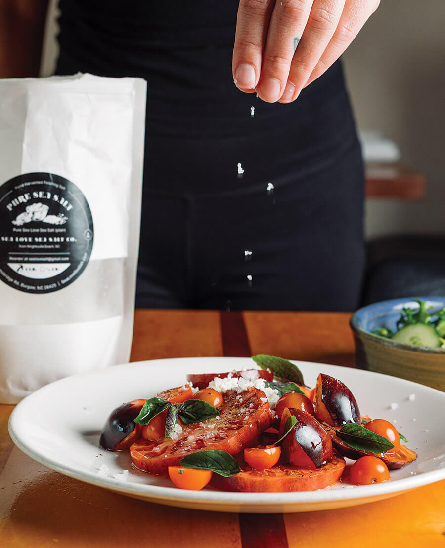Sprinkling Sea Love Salt on tomatoes