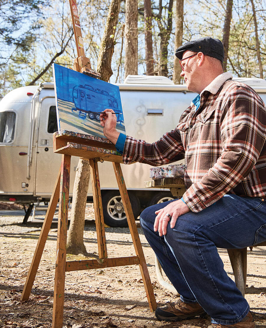 Jared Slack painting an Airstream camper