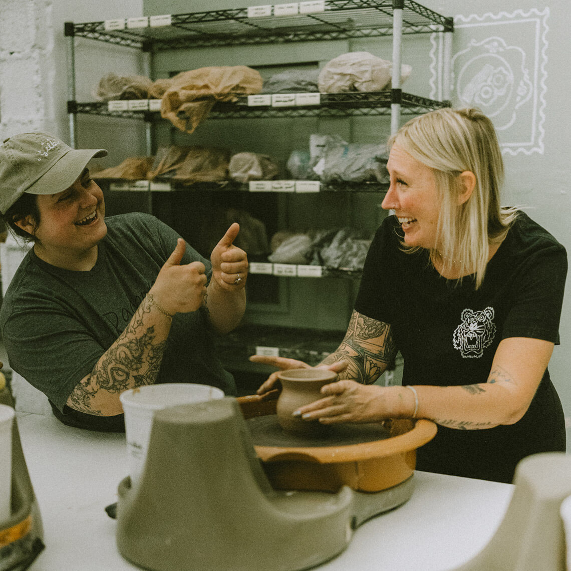 Ashley Merklinger coaches a student at the potter's wheel