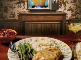 TV dinner on a plate in front of a vintage television set