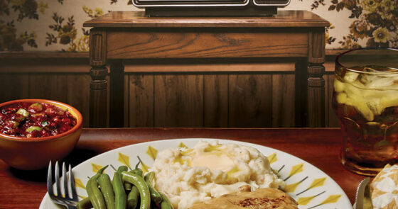 TV dinner on a plate in front of a vintage television set